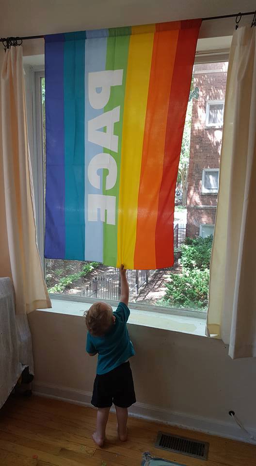 Exley reaching up to the LGBTQ flag
